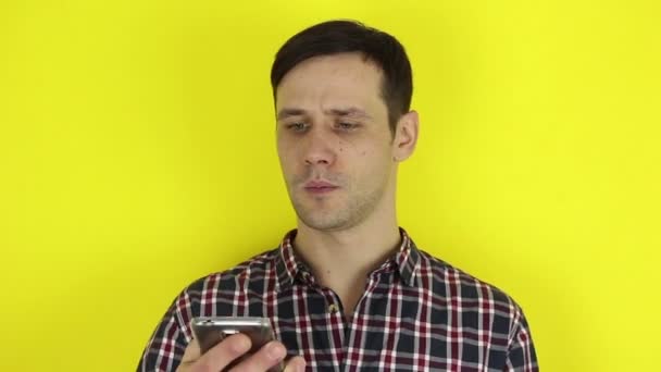 Ein Lustiger Süßer Kerl Blättert Auf Seinem Smartphone Durch Den — Stockvideo