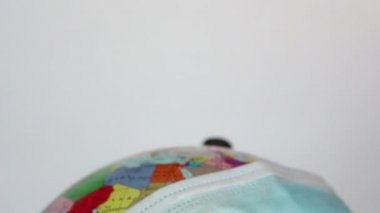 Dünya küresi tıbbi bir maske takıyor. Bir Dünya küresi üzerinde tıbbi maske takılır. Dünya karantinası, koronavirüs salgını. Dünya karantina sembolü.