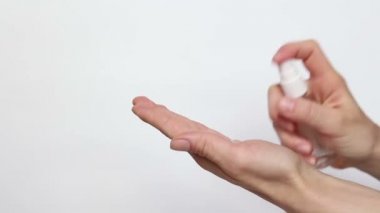Genç bir kız ellerini antiseptikle dezenfekte ediyor. Genç bir kız önlem için ellerine antiseptik serpiyor..