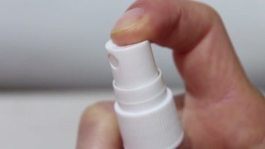 Genç bir kız ellerini antiseptikle dezenfekte ediyor. Genç bir kız önlem için ellerine antiseptik serpiyor. Eller yukarı..