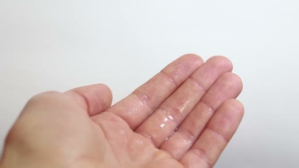 Un jeune homme désinfecte ses mains avec un antiseptique. Le jeune homme pulvérise un antiseptique sur ses mains pour la prévention. Mains en l'air .