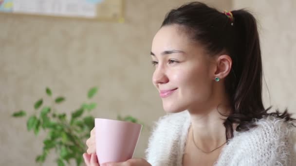 Ένα Νεαρό Ελκυστικό Κορίτσι Πίνει Καφέ Από Ένα Ροζ Φλιτζάνι — Αρχείο Βίντεο