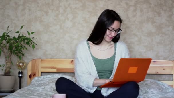 Νεαρή Ελκυστική Κοπέλα Εργάζεται Αποστάσεως Ενώ Κάθεται Στο Κρεβάτι Στο — Αρχείο Βίντεο