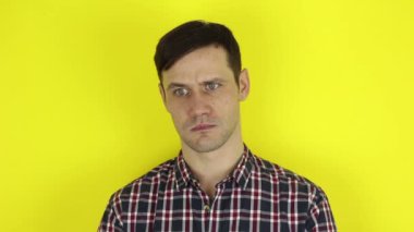 Komik, sevimli bir adam aktif olarak mor bir balonla oynuyor. Genç bir adamın portresi, aktif olarak neşeyi ifade ediyor ve mor bir balonla oynuyor. Güzel bir adam doğum gününü bir balonla oynayarak kutluyor. Sarı arka planda bir portre.