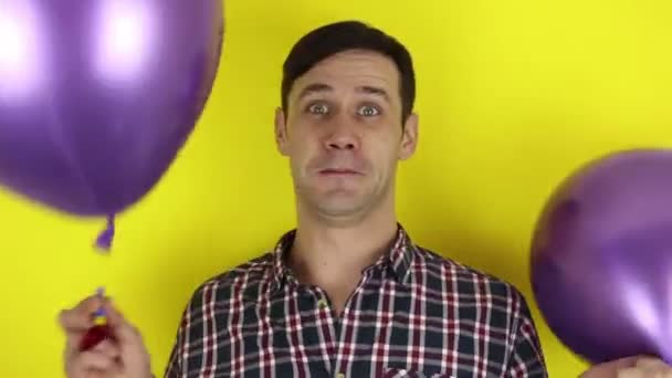 Funny Cute Guy Actively Plays Purple Balloon Blows Party Horn — Stock Video