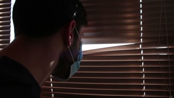 Young Handsome Guy Medical Face Mask Looks Window Blinds Young — Stock Video