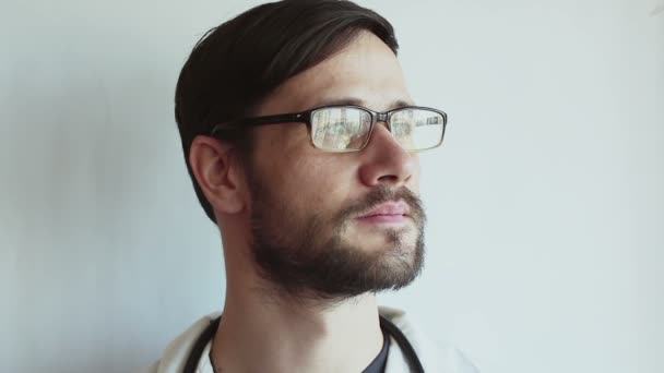 Joven Médico Guapo Con Gafas Sonríe Ampliamente Médico Joven Está — Vídeos de Stock