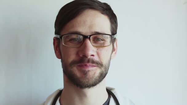 Joven Médico Guapo Con Gafas Sonríe Ampliamente Médico Joven Está — Vídeo de stock