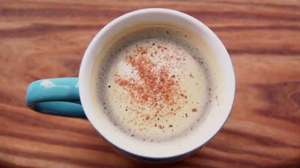 木のテーブルの上には香り高いコーヒーが立っている 泡のアロマコーヒー おいしいミルクフォームでコーヒーを活性化 — ストック動画