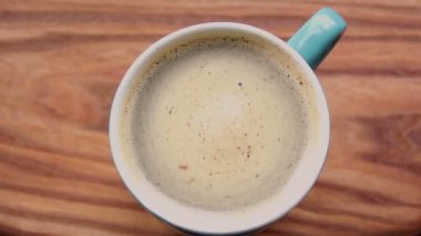 Ahşap bir masada duran bir fincan aromatik kahve..