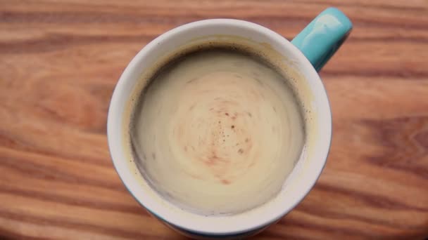 A cup of aromatic coffee stands on a wooden table. — Stock Video