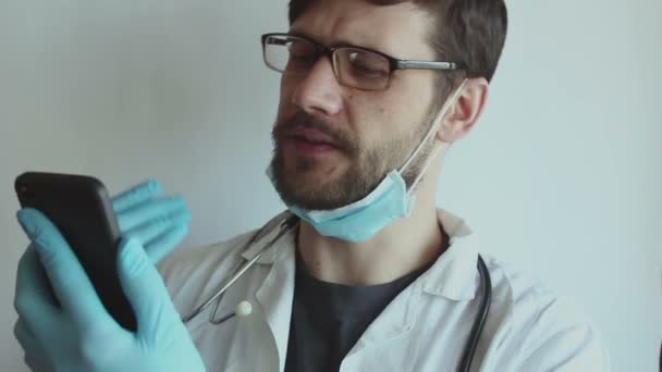 Joven Médico Guapo Con Gafas Una Mascarilla Médica Proporciona Paciente — Vídeo de stock