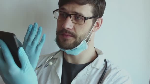 Joven Médico Guapo Con Gafas Una Mascarilla Médica Proporciona Paciente — Vídeo de stock