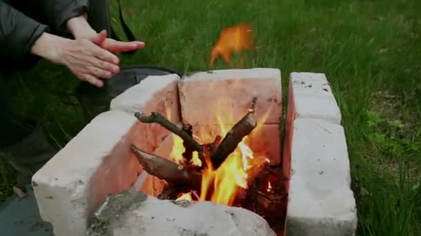 Młoda Dziewczyna Rozgrzewa Ręce Siedząc Przy Ognisku Przytulne Płonące Ognisko — Wideo stockowe