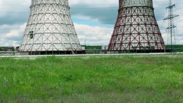 Vista de la central eléctrica y torres de refrigeración. El humo sale de una torre de refrigeración de una central eléctrica en funcionamiento. Las torres de refrigeración de una central termoeléctrica se reflejan en una — Vídeo de stock