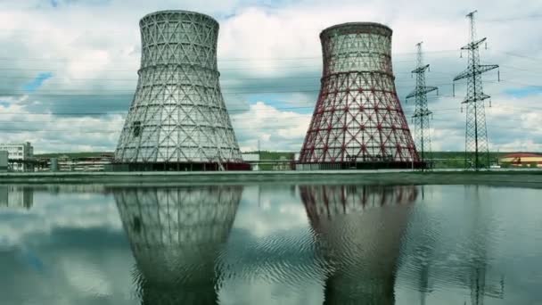 Vista de la central eléctrica y torres de refrigeración. El humo sale de una torre de refrigeración de una central eléctrica en funcionamiento. Las torres de refrigeración de una central termoeléctrica se reflejan en una — Vídeo de stock