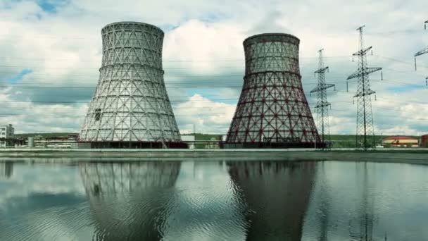 Vista da usina e torres de resfriamento. A fumaça sai de uma torre de resfriamento de uma usina de energia operacional. Torres de resfriamento de uma usina termoelétrica são refletidas em um técnico — Vídeo de Stock