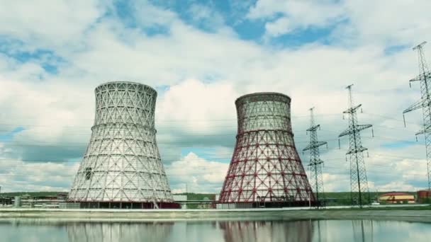 Widok na elektrownię i wieże chłodnicze. Dym wylatuje z chłodni działającej elektrowni. Wieże chłodnicze elektrowni cieplnej są odzwierciedlone w technicznym — Wideo stockowe