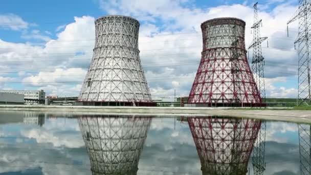 Vista de la central eléctrica y torres de refrigeración. El humo sale de una torre de refrigeración de una central eléctrica en funcionamiento. Las torres de refrigeración de una central termoeléctrica se reflejan en una — Vídeos de Stock