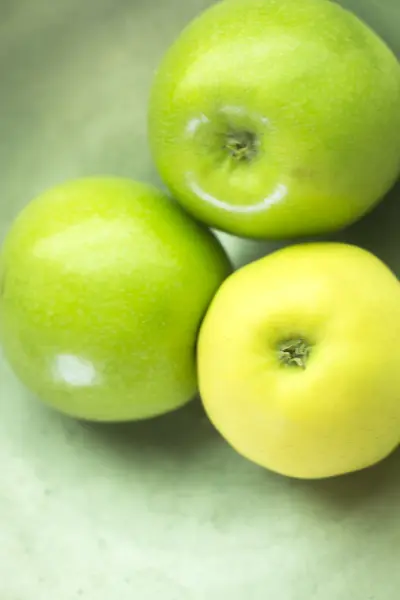 Three green apples on dish — Stock Photo, Image