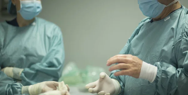 Chirurg trekt handschoenen aan. — Stockfoto