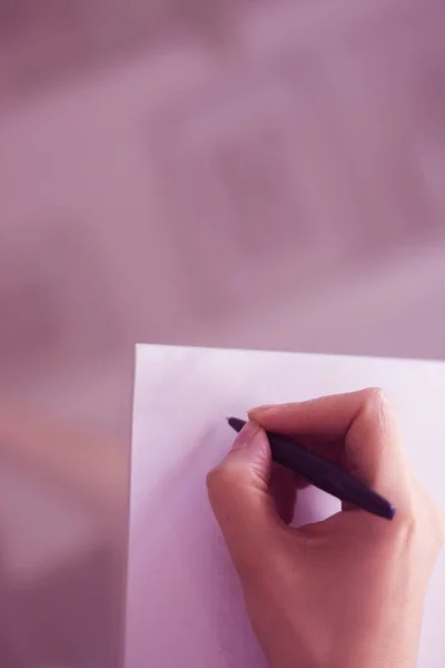Junge Frau schreibt auf Papier — Stockfoto