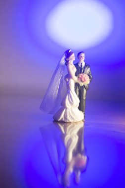 Düğün çifti pasta üstte plastik figürler smokin gece elbisesi, beyaz gelinlik peçesi.