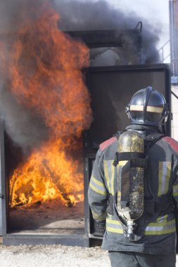 İtfaiyeci yangın söndürme istasyonunu söndürüyor. Acil durum güvenlik tatbikatı prosedürü..