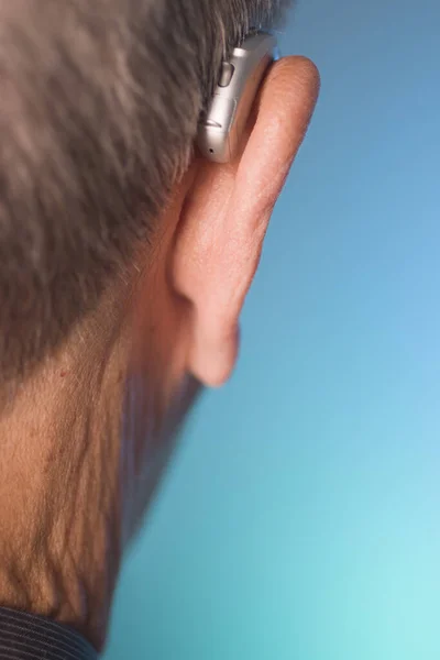 白人白人高齢者男性身に着けています現代的なデジタル補聴器で耳の中に灰色の髪 — ストック写真