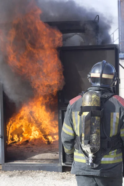 Firefighter putting out fire training station extinguisher backdraft emergency safety drill procedure.