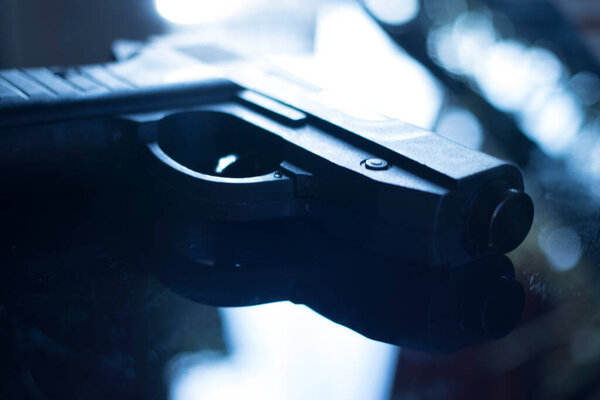 Automatic pistol handgun in artistic light effect moody atmospheric photo creative artistic closeup