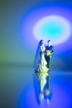 Düğün çifti pasta üstte plastik figürler smokin gece elbisesi, beyaz gelinlik peçesi.