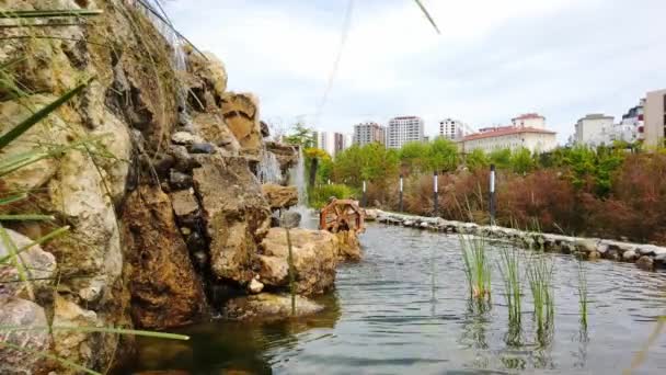 Decorative artificial waterfall in city park. — Stock Video