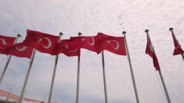 Mavi gökyüzüne karşı Türk bayrakları gelişiyor, beyaz bulutlar. Vatanseverlik kavramı.