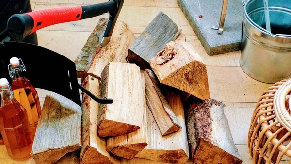 Hasır sepet levha metal ve baltayla yakacak oduna çivilenmiş gül şarabı şişelerinin yanında.