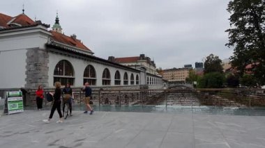 Ljubljana 'daki yaya köprüsü. Eski şehir manzarası. İnsanlar köprüde yürür.