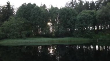 Güneş ağaçların arasından geçiyor. Güneş ışığının suyunda yansıma.