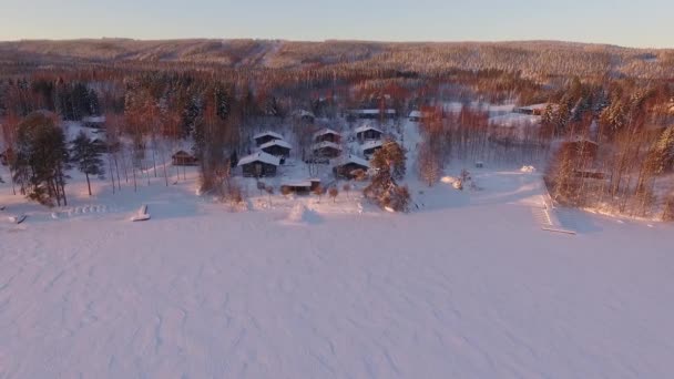 Dron Lata Nad Domami Zamarzniętym Jeziorem Wszędzie Śnieg Zachodzie Słońca — Wideo stockowe