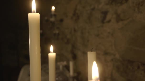 蜡烛在古城堡大厅的桌子上燃烧 把摄像机的焦点从蜡烛转到墙壁上 — 图库视频影像