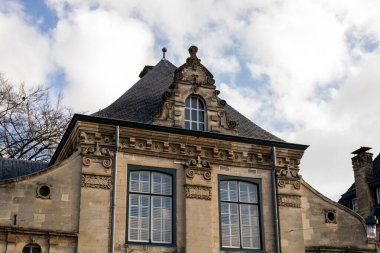 Valkenburg, The Netherlands - March 7, 2020: Top facade of a structure built in 1661. nice blue sky with some clouds. old ancient building.