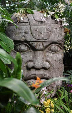 Endonezya tarzında çiçekli büyük bir kafa şeklinde dekoratif taş heykel.