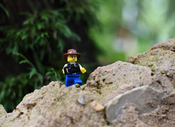 Makro dünyada kameralı şapkalı bir lego adam.
