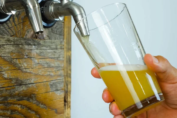 Ρίχνεις μπύρα σ 'ένα ποτήρι από τη βρύση στο μπαρ. Φιάλη μπύρας. — Φωτογραφία Αρχείου