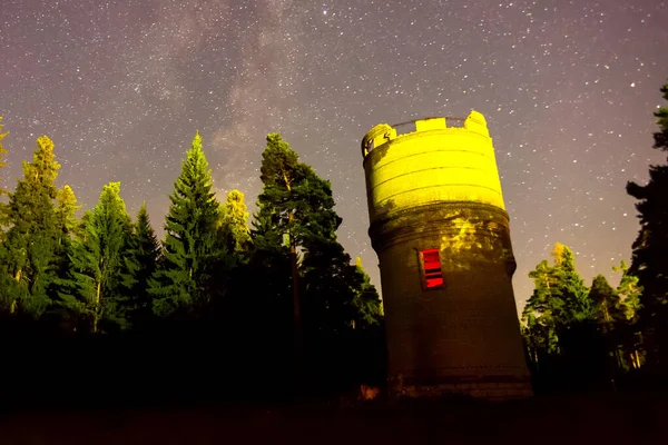 Cielo estrellado sobre el bosque y la torre de agua. Atrás cielo estrellado — Foto de Stock