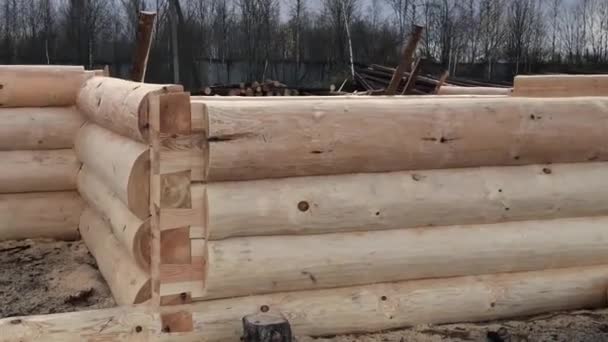 Preparación de troncos para el montaje de la estructura. Materiales para una casa de madera. Secado y montaje de casa de madera en una base de construcción . — Vídeo de stock