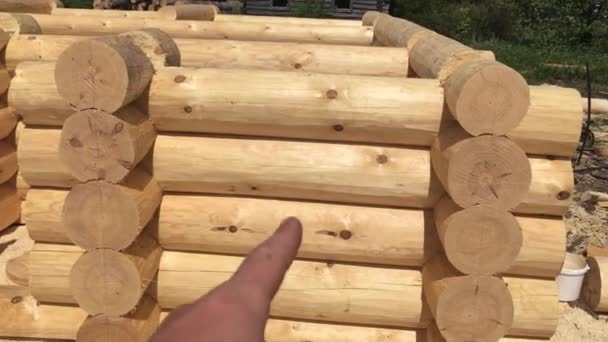 Preparación de troncos para el montaje de la estructura. Materiales para una casa de madera. Secado y montaje de casa de madera en una base de construcción . — Vídeos de Stock