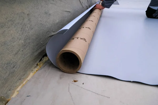 Rolls of polymer coating for roof. Deployment of a roof covering roll. — Stock Photo, Image