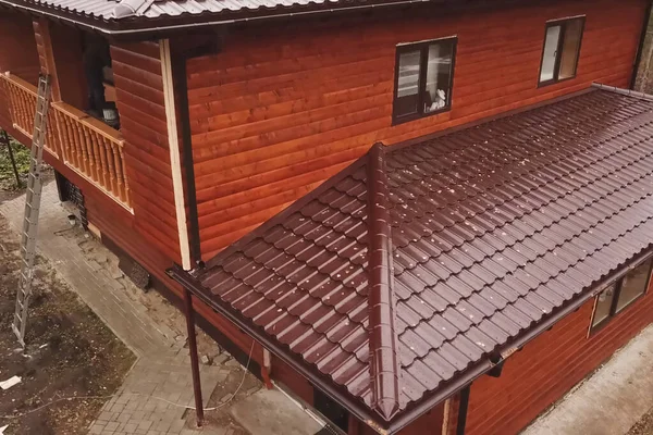 Kahverengi metal çatılı bir ev. Çatı ve metal kaplama. — Stok fotoğraf