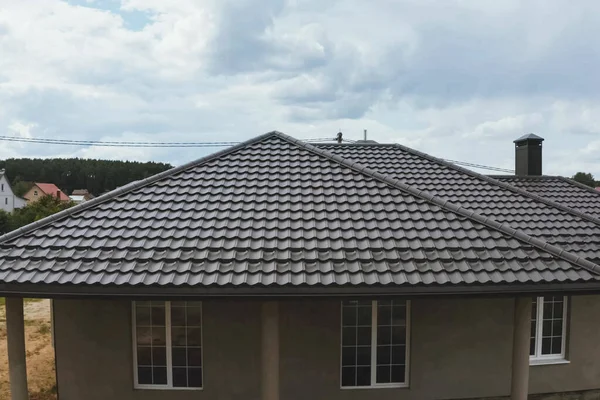 Casa com um telhado de metal marrom. Telhado de metal ondulado e metal ro — Fotografia de Stock