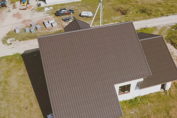 Mattonelle di metallo marrone sul tetto della casa. tetto in metallo ondulato — Foto Stock